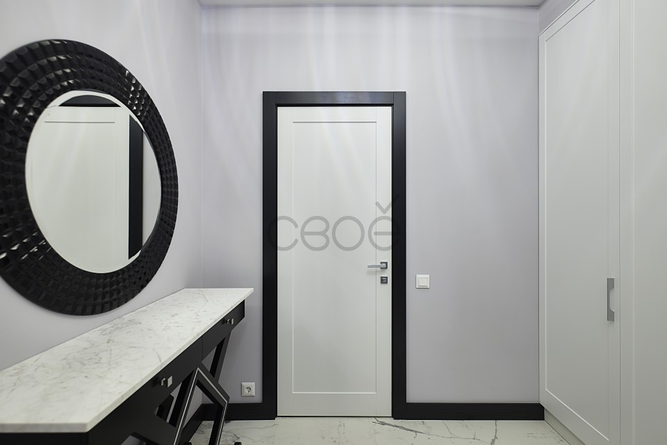 Стильные белые межкомнатные двери в обрамлении черных наличников